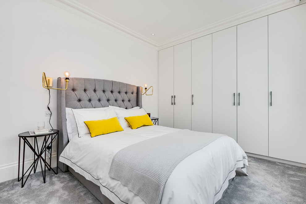 Modelo de dormitorio escandinavo con paredes blancas, moqueta y suelo gris