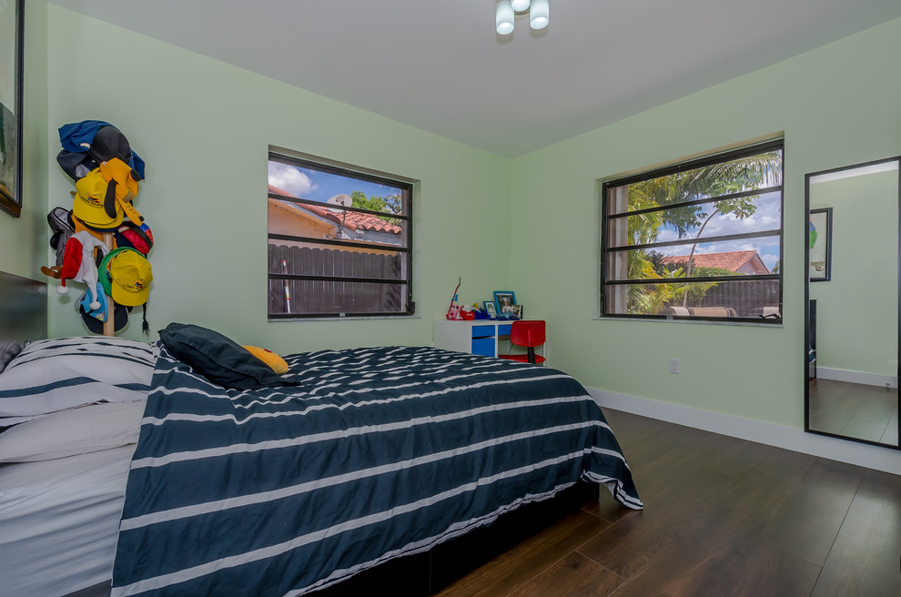 Exemple d'une chambre d'amis tendance de taille moyenne avec un mur vert et parquet foncé.