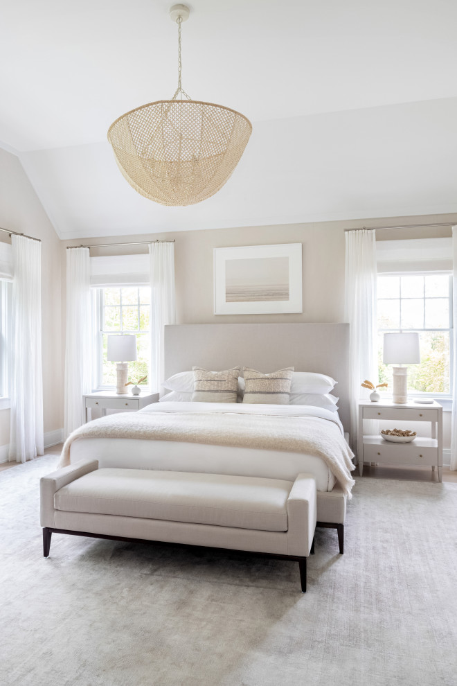 Example of a large classic master light wood floor and brown floor bedroom design in New York with beige walls and no fireplace