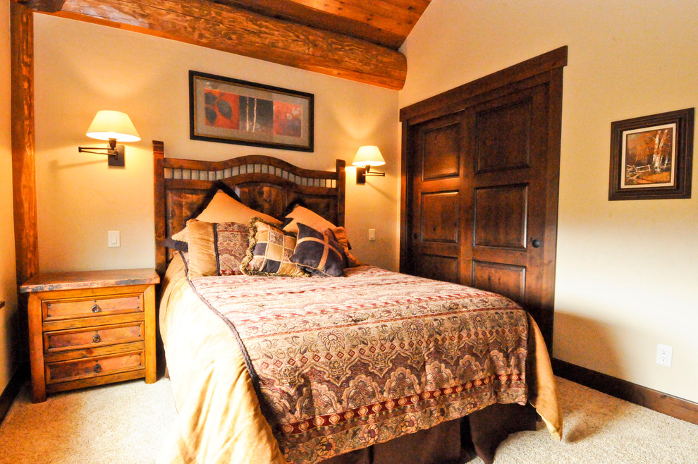 Esempio di una camera degli ospiti rustica di medie dimensioni con pareti beige e moquette
