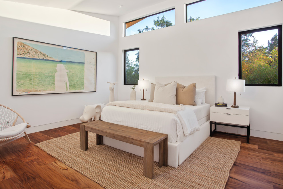 Photo of a contemporary bedroom in Los Angeles with white walls, dark hardwood flooring and brown floors.