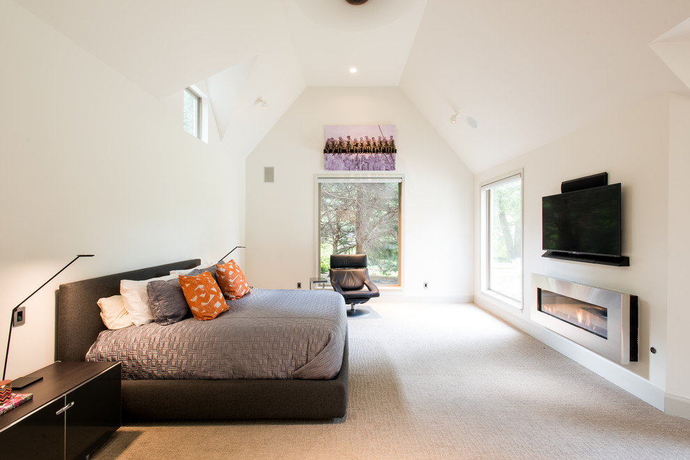 Стильный дизайн: большая хозяйская спальня в современном стиле с белыми стенами, ковровым покрытием, горизонтальным камином и фасадом камина из металла - последний тренд