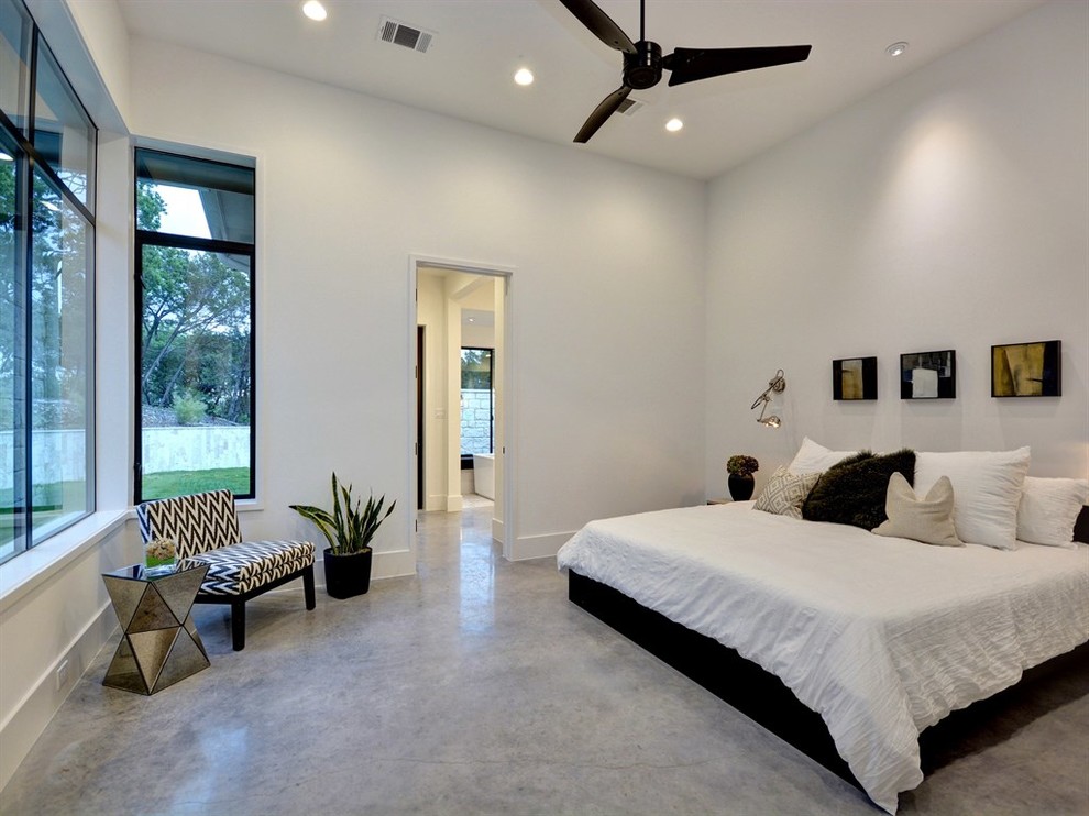 Geräumiges Modernes Hauptschlafzimmer ohne Kamin mit weißer Wandfarbe und Betonboden in Austin