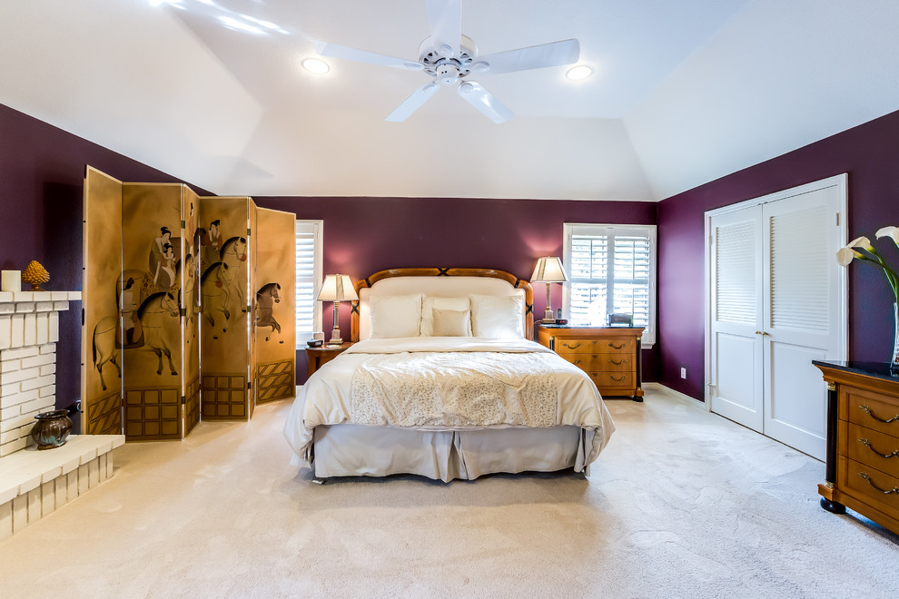 Modelo de dormitorio principal clásico renovado grande con paredes púrpuras, moqueta, todas las chimeneas y marco de chimenea de ladrillo