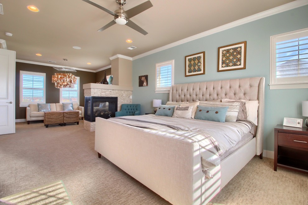 Diseño de dormitorio principal clásico renovado grande con paredes azules, moqueta, chimenea de doble cara, marco de chimenea de baldosas y/o azulejos y suelo beige