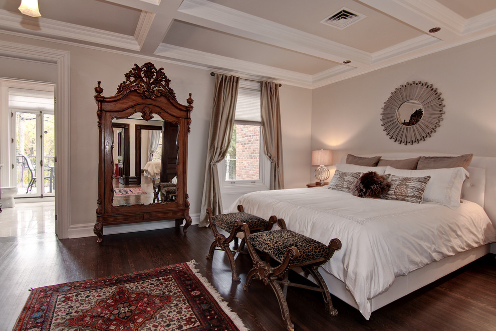 Immagine di una camera matrimoniale classica con pareti beige e pavimento in legno massello medio
