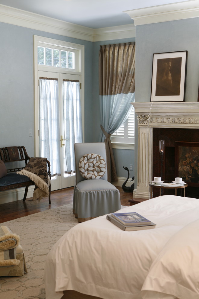 На фото: большая хозяйская спальня в стиле неоклассика (современная классика) с синими стенами, паркетным полом среднего тона, стандартным камином и фасадом камина из дерева с