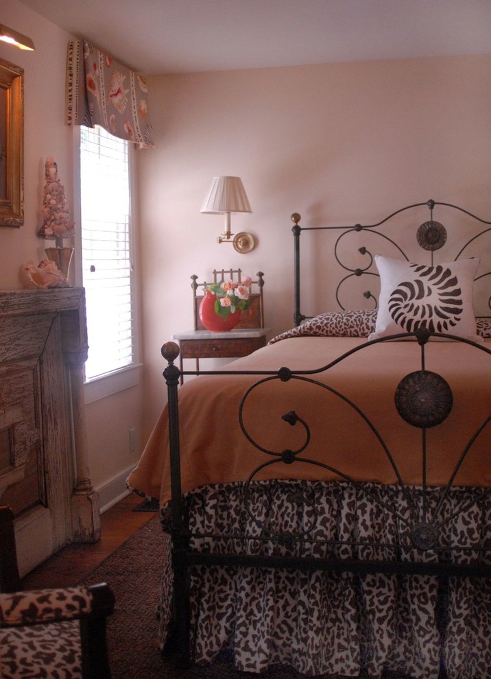 Cette image montre une petite chambre parentale traditionnelle avec un mur rose, un sol en bois brun et aucune cheminée.