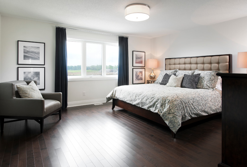 Imagen de dormitorio principal grande con paredes beige y suelo de madera oscura