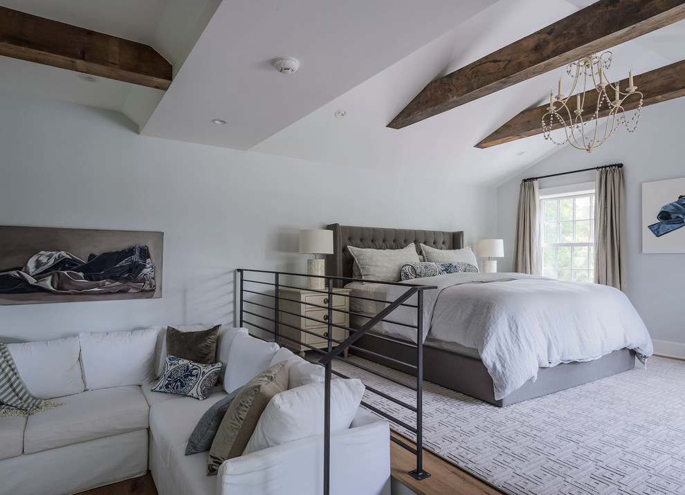 Diseño de dormitorio tipo loft de estilo de casa de campo grande sin chimenea con paredes grises y suelo de madera en tonos medios