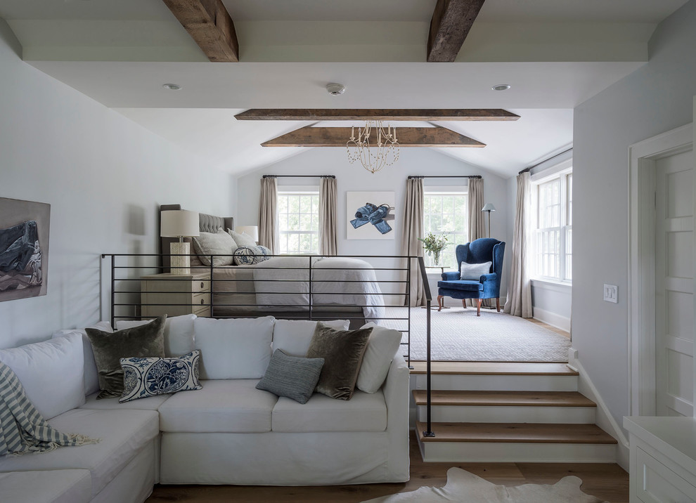 Großes Landhausstil Schlafzimmer im Dachboden ohne Kamin, im Loft-Style mit grauer Wandfarbe und braunem Holzboden in New York