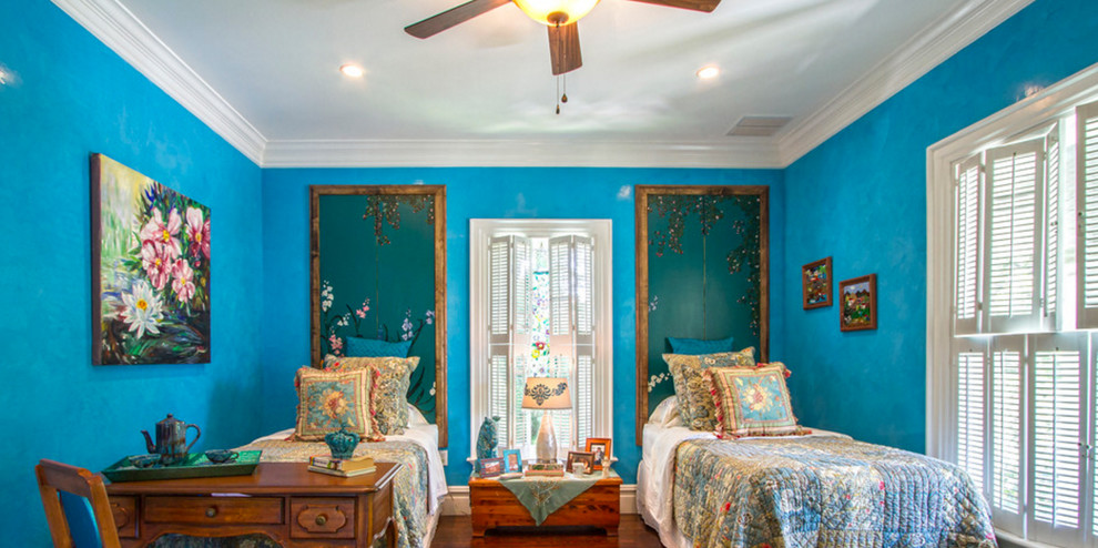 Large eclectic guest medium tone wood floor and brown floor bedroom photo in Austin with blue walls