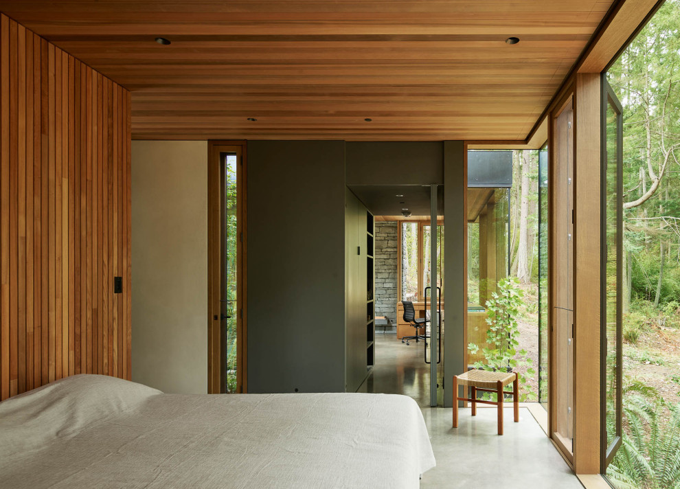 Modernes Hauptschlafzimmer mit Betonboden, brauner Wandfarbe, grauem Boden, Holzdecke und Holzwänden in Seattle