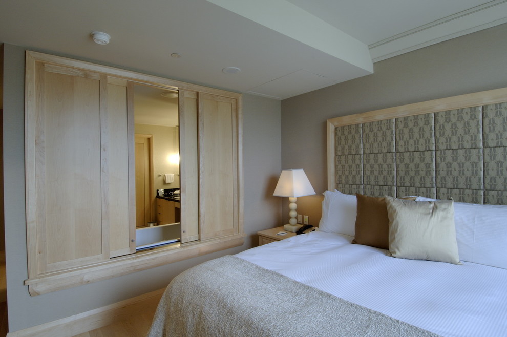 Стильный дизайн: спальня в современном стиле с серыми стенами и светлым паркетным полом без камина - последний тренд