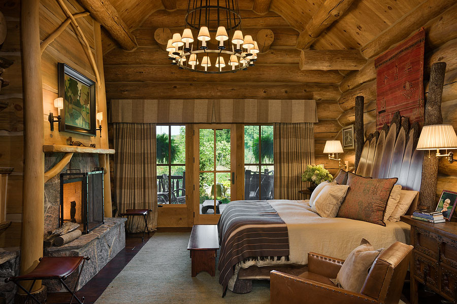 Inspiration for a huge rustic master dark wood floor bedroom remodel in Chicago with brown walls and a stone fireplace