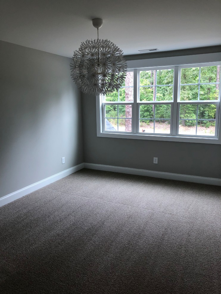 Cette image montre une chambre minimaliste de taille moyenne avec un mur gris et aucune cheminée.