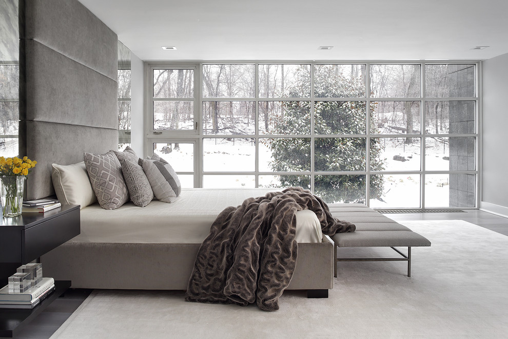 Modelo de dormitorio contemporáneo con paredes grises, suelo de madera oscura y suelo gris