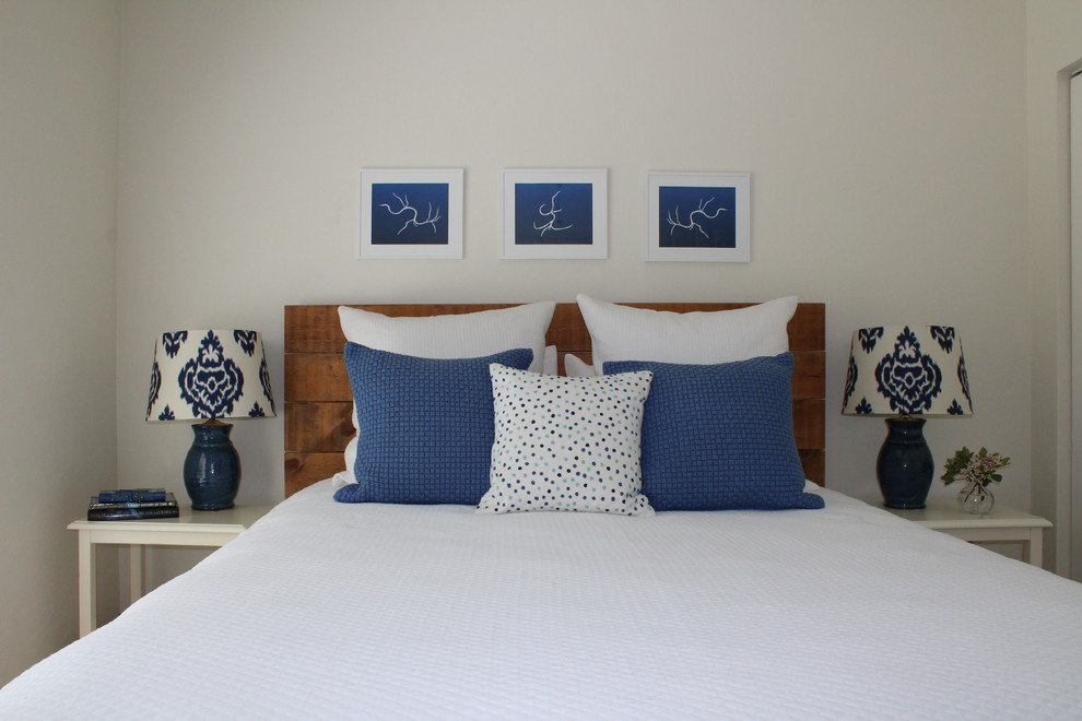 Inspiration for a small coastal guest bedroom in Orlando with white walls and light hardwood flooring.
