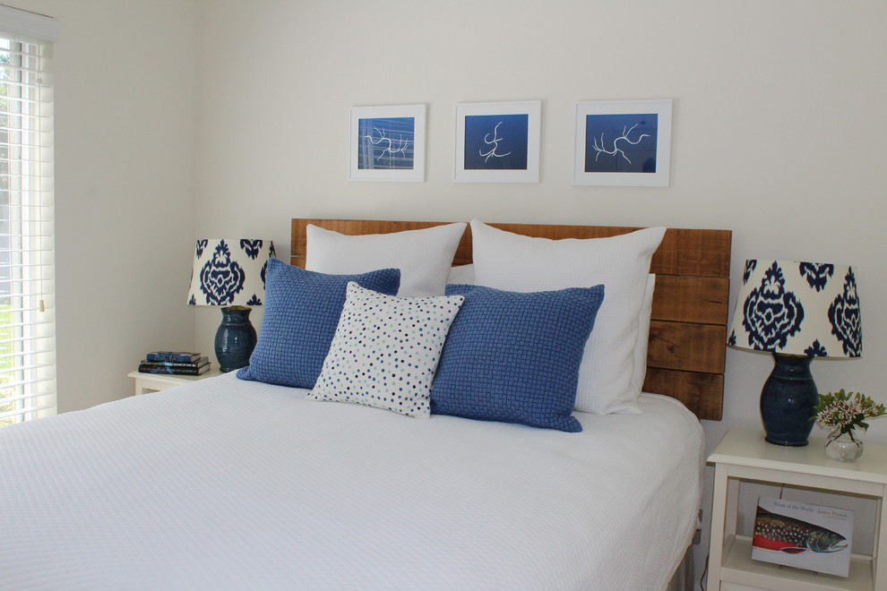 Diseño de habitación de invitados costera pequeña con paredes blancas y suelo de madera clara