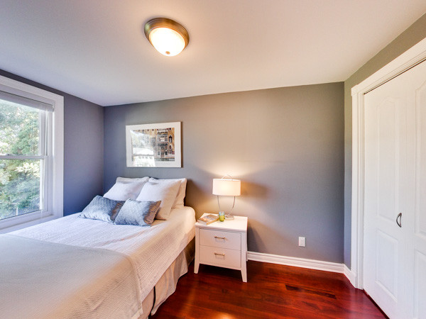 Foto de dormitorio principal minimalista con suelo de madera en tonos medios