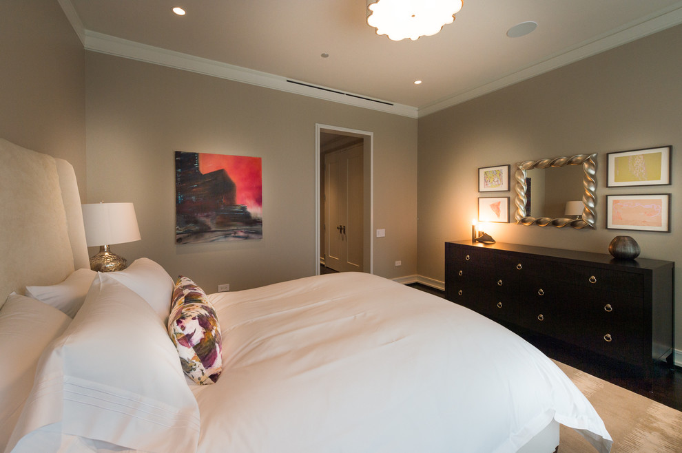 Ejemplo de dormitorio actual con suelo de madera oscura y paredes beige