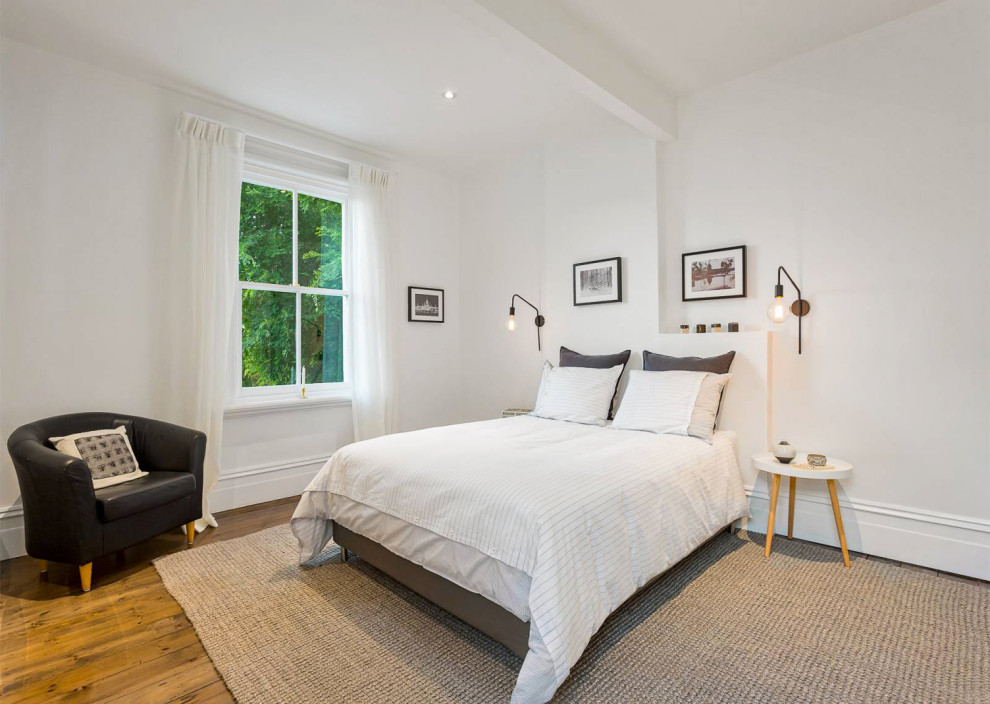 Inspiration för stora minimalistiska sovrum, med vita väggar och mörkt trägolv
