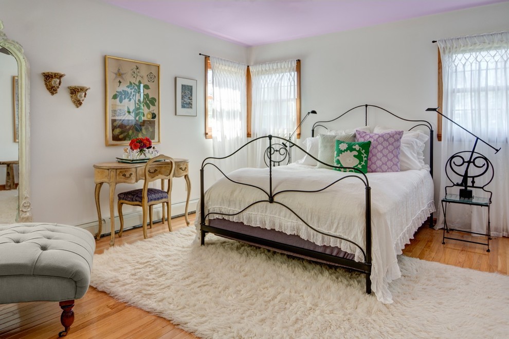This is an example of an eclectic bedroom in Boston with white walls.