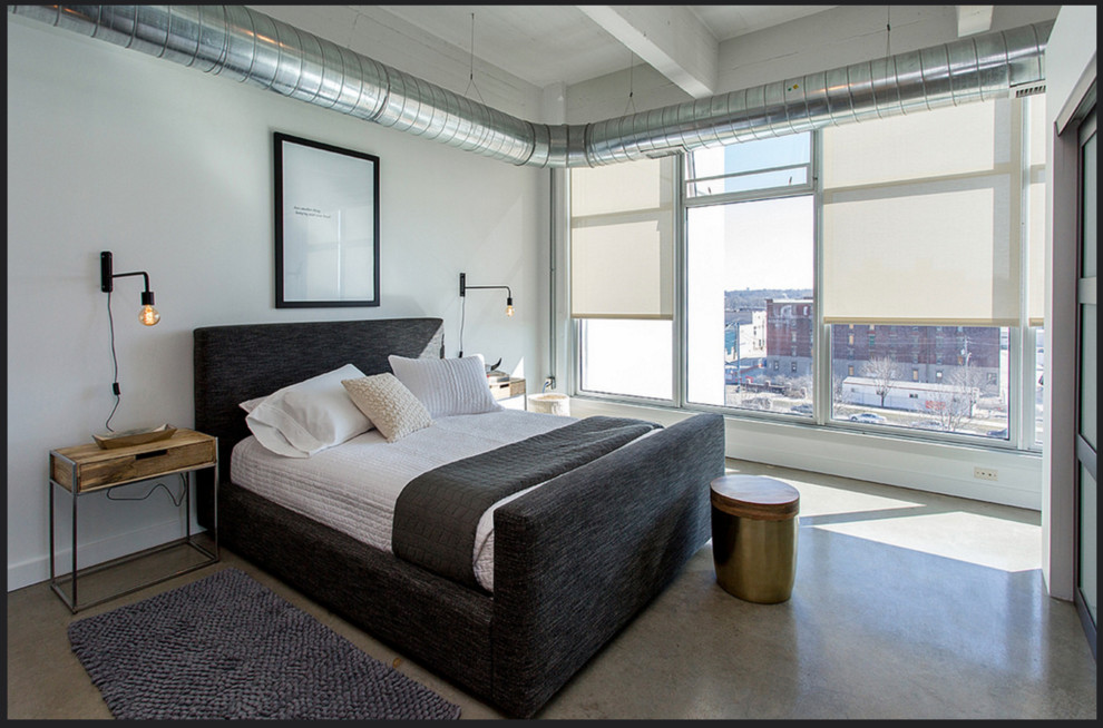 Modelo de dormitorio principal moderno de tamaño medio sin chimenea con paredes blancas, suelo de cemento y suelo gris