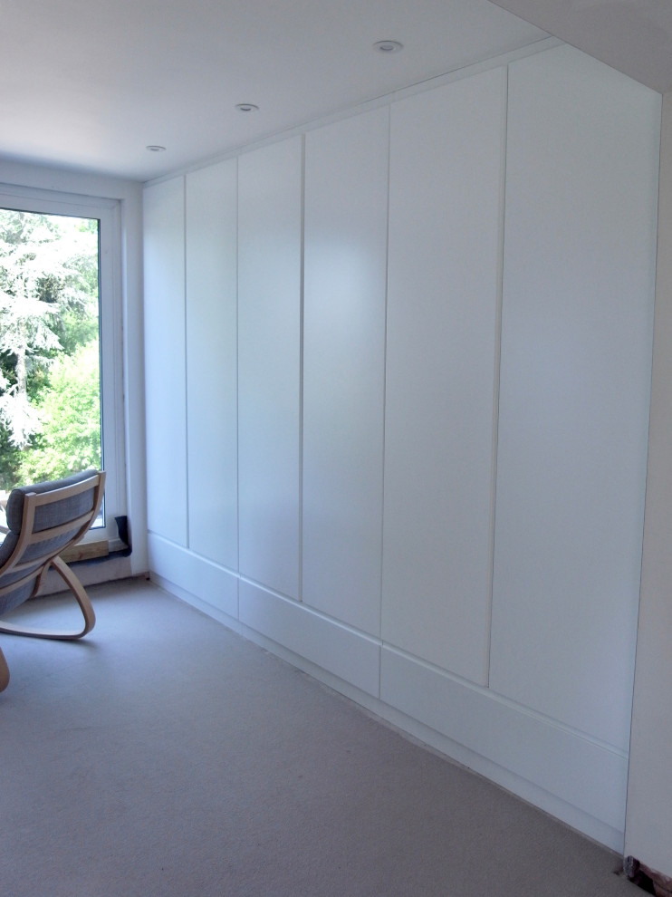 Aménagement d'une grande chambre avec moquette contemporaine avec un mur blanc et un sol beige.