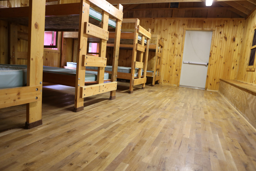 Cette image montre une grande chambre chalet avec un mur multicolore et un sol en bois brun.