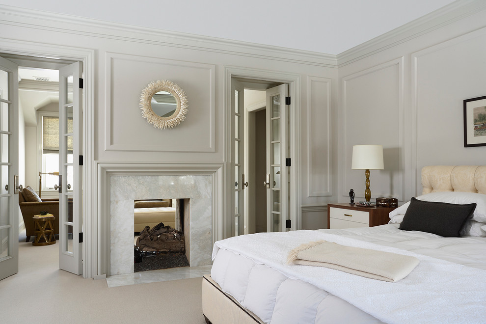 Modelo de dormitorio principal clásico renovado con paredes beige, moqueta y chimenea de doble cara