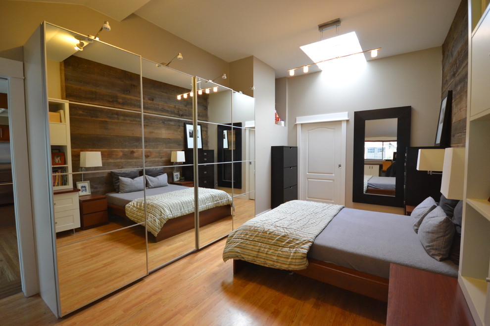 Idee per una camera matrimoniale american style di medie dimensioni con pareti grigie e parquet chiaro