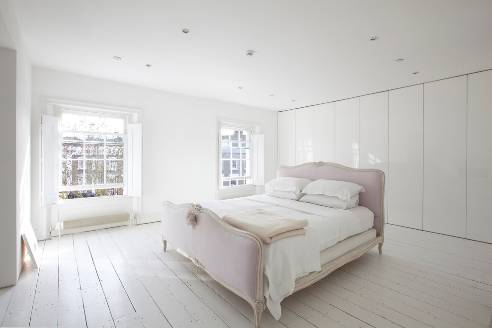 На фото: большая хозяйская спальня в современном стиле с белыми стенами и деревянным полом с