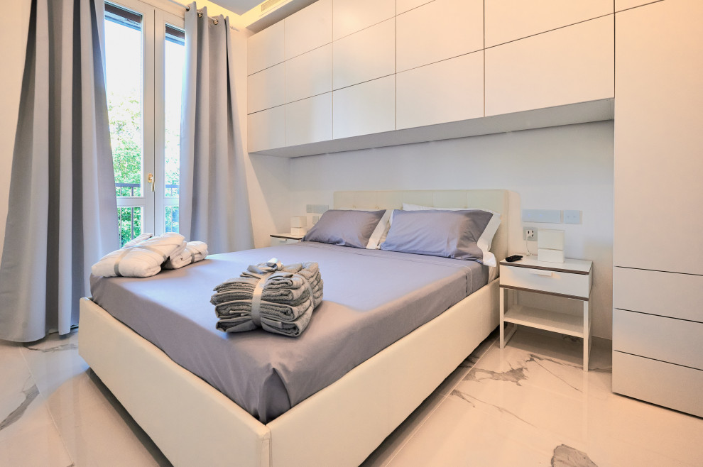 На фото: хозяйская спальня в стиле модернизм с белыми стенами, мраморным полом и желтым полом с