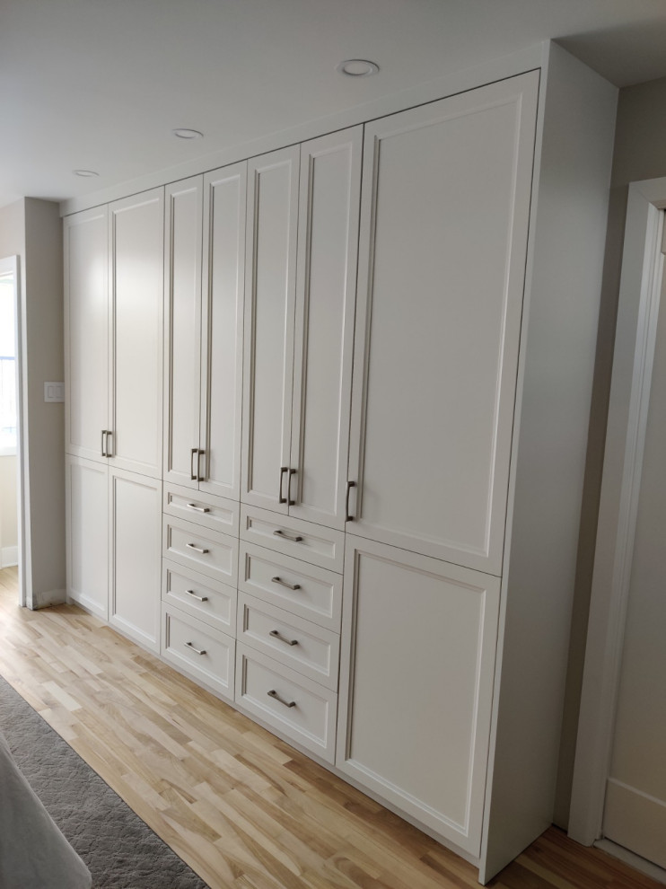 Imagen de dormitorio principal moderno de tamaño medio con paredes beige y suelo de madera clara