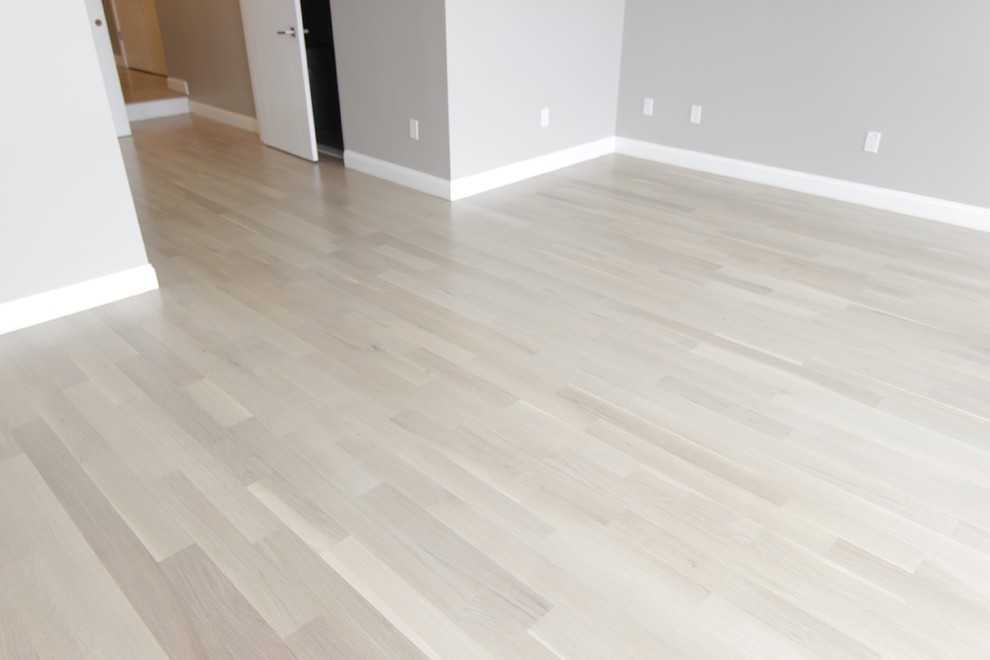 Foto de dormitorio principal minimalista grande con paredes grises, suelo de madera clara y suelo blanco