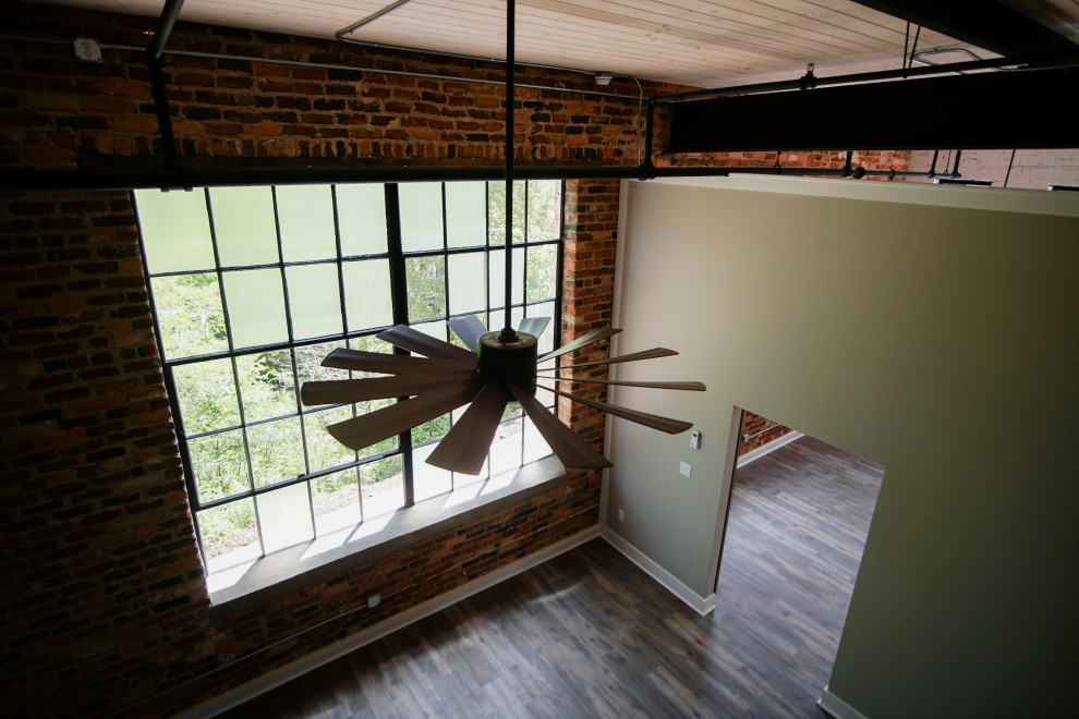 Mittelgroßes Industrial Gästezimmer ohne Kamin mit weißer Wandfarbe, Vinylboden, braunem Boden, Holzdecke und Ziegelwänden in Atlanta