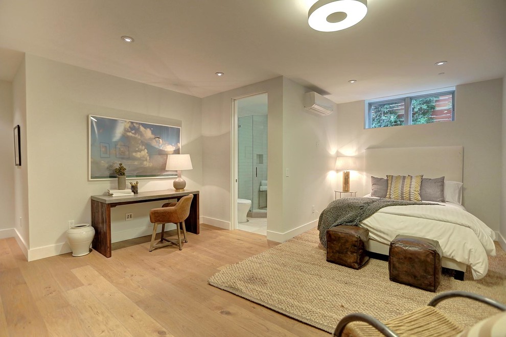 This is an example of a medium sized modern guest bedroom in Los Angeles with grey walls and medium hardwood flooring.