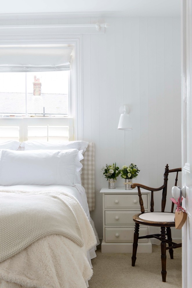 Small beach style carpeted bedroom photo in Kent with white walls