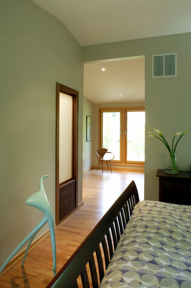 Imagen de dormitorio principal retro con paredes verdes y suelo de madera en tonos medios