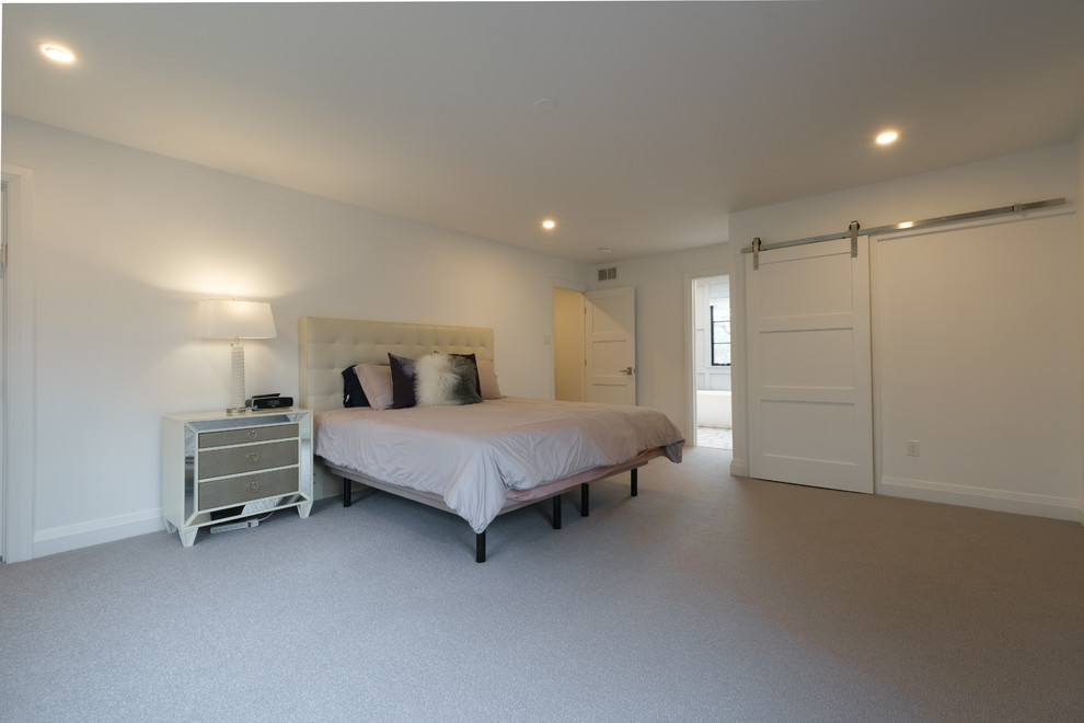 This is an example of a large modern master bedroom in Philadelphia with white walls, carpet, no fireplace and grey floors.