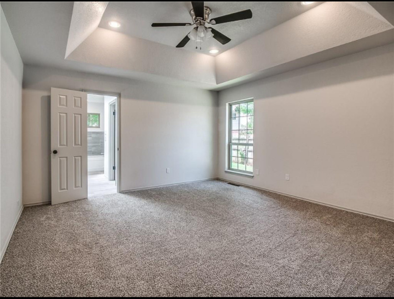 Cette photo montre une grande chambre chic avec un mur beige, aucune cheminée et un sol marron.