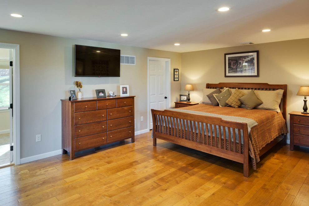 Modelo de dormitorio principal tradicional de tamaño medio sin chimenea con paredes beige y suelo de madera clara