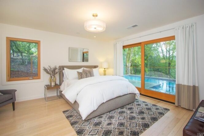 Cette image montre une chambre parentale minimaliste de taille moyenne avec un mur blanc, parquet clair et un sol beige.