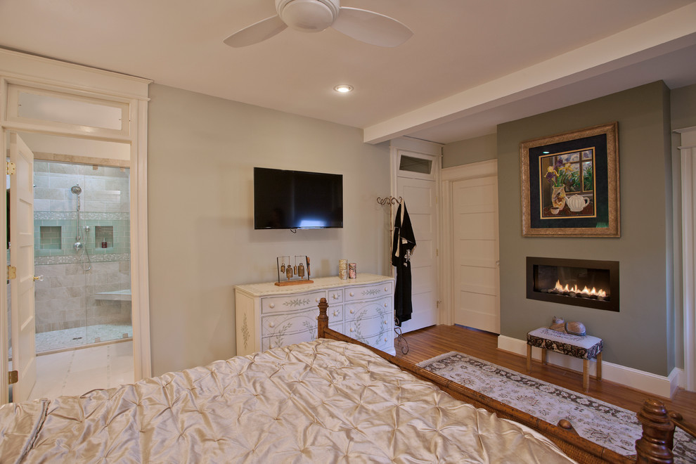 Idées déco pour une chambre parentale classique de taille moyenne avec un mur vert, un sol en bois brun et une cheminée ribbon.