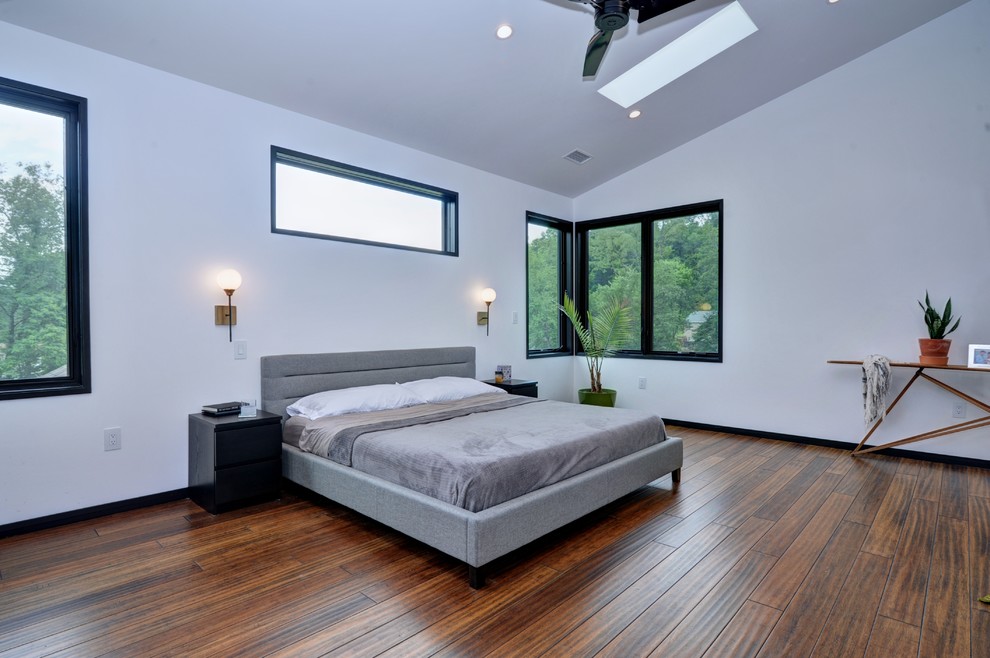 Example of a large urban master bamboo floor and brown floor bedroom design in Other with white walls