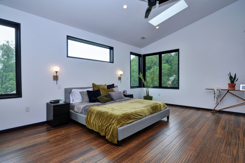 Ejemplo de dormitorio principal industrial grande con paredes blancas, suelo de bambú y suelo marrón