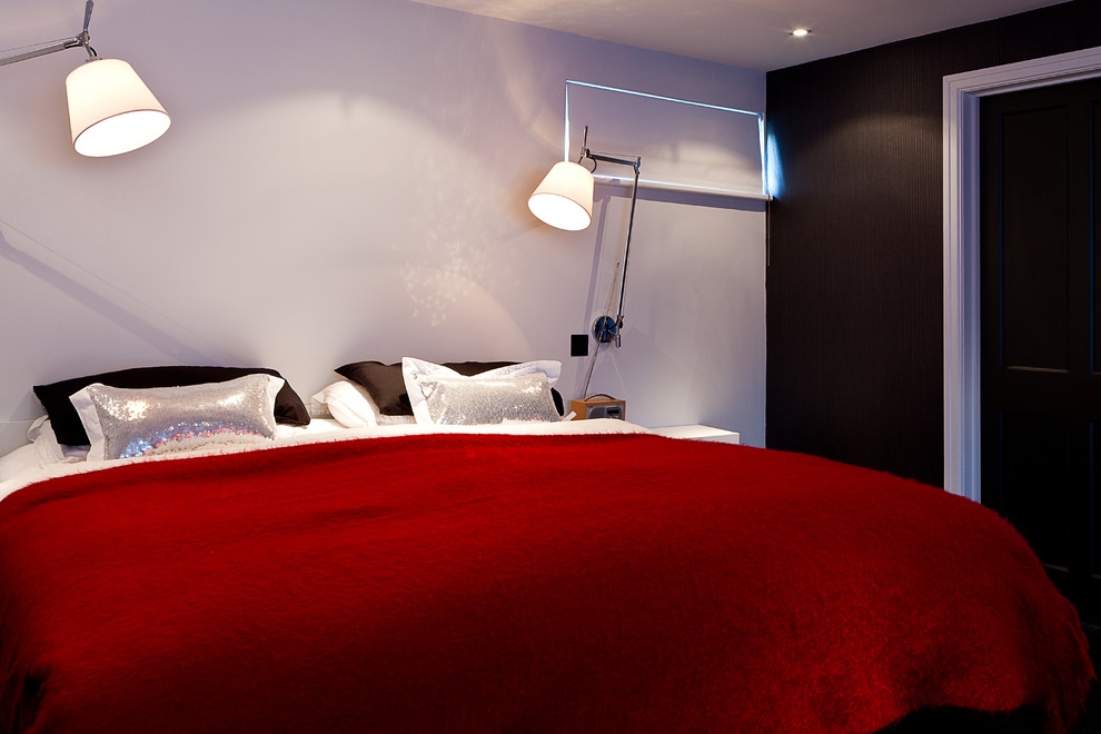 This is an example of a contemporary bedroom in London with white walls.