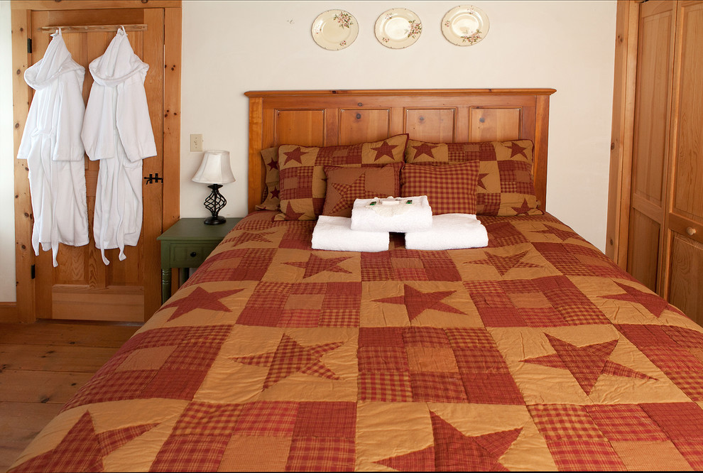 Diseño de habitación de invitados tradicional de tamaño medio con paredes blancas y suelo de madera en tonos medios