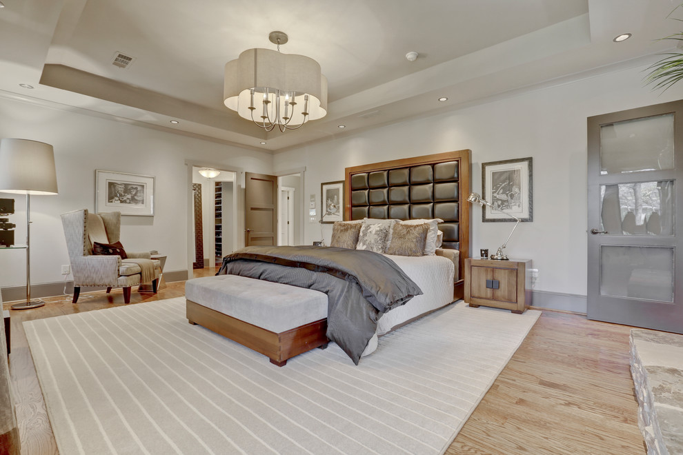 アトランタにある広いトランジショナルスタイルのおしゃれな主寝室 (白い壁、無垢フローリング、標準型暖炉、石材の暖炉まわり、茶色い床、グレーとブラウン) のインテリア